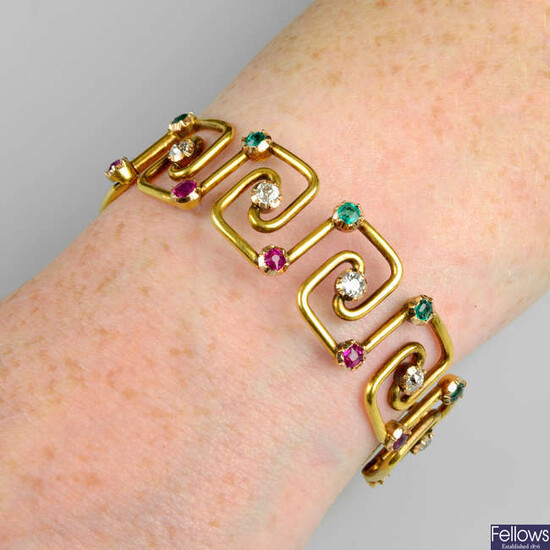 An early 20th century 18ct gold emerald, diamond and ruby bangle.