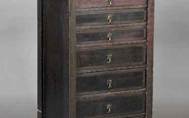 An early 20th century Arts and Crafts style painted softwood Wellington chest of seven graduated dra