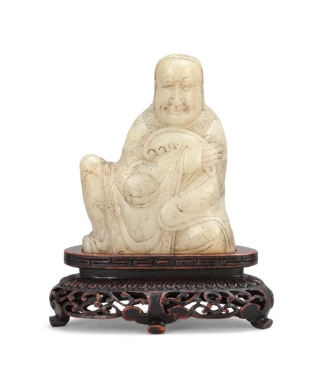 CHINESE WHITE SOAPSTONE SEAL In the form of a seated lohan draped in flowing robes with a brocade design and holding a ruyi fungus....