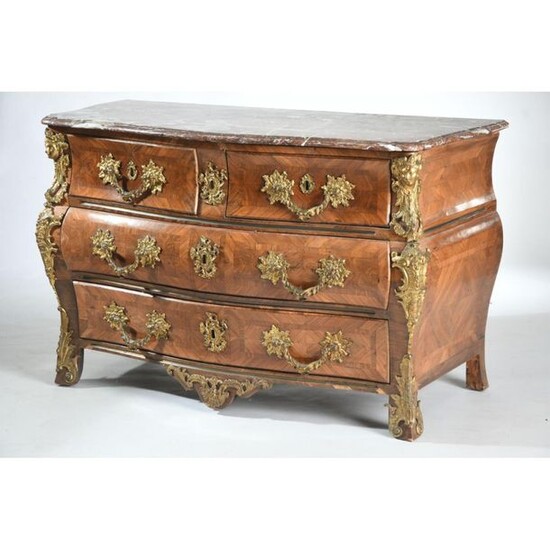COMMODITY TOMB LOUIS XV curved all sides in rosewood and violet veneer. It opens by 4 drawers on 3 rows framed by uprights with pinched ribs. Rich and beautiful ornamentation of finely chiselled gilded bronzes decorated with busts of women, foliage...