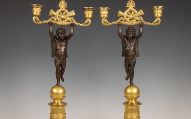 Frankrijk, paar vuurvergulde- en zwart gepatineerde bronzen twee lichts kandelaars, Empire, 19e eeuw;