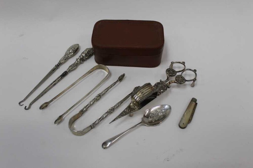 Group of silver to include two pairs of Georgian sugar tongs, silver fruit knife, silver button hooks, grapefruit spoon and silver plated candle snuffers.