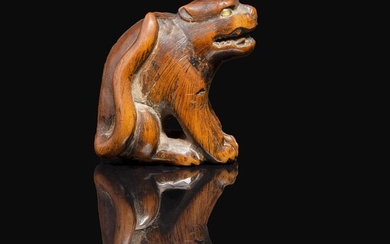 NETSUKE en bois représentant un tigre assis, les yeux incrustés de corne blonde. Japon, XIXe siècle. A WOOD NETSUKE OF A TIGE...