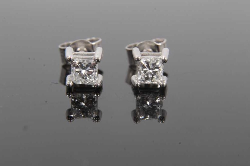 Pair of diamond single stone earrings, each with a princess cut diamond in 18ct white gold four claw setting, hallmarked London 2004. Estimated total diamond weight approximately 0.40cts
