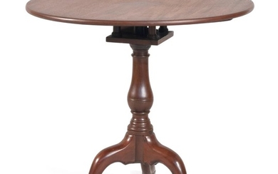 QUEEN ANNE BIRDCAGE TILT-TOP TEA TABLE In mahogany, with a vasiform pedestal raised on three bold cabriole legs ending in snake feet...