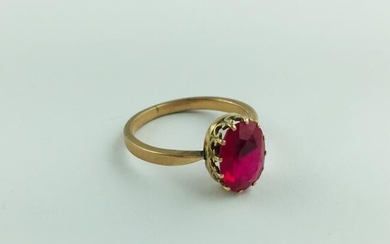 Ring in red gold with a central oval cut synthetic ruby