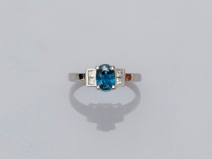 Ring in white gold, 750 MM, centered on a transparent oval sapphire weighing 1.25 carat and set with princess cut diamonds, size : 53, weight : 2.85gr. rough.