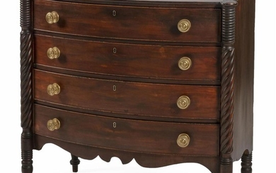 SHERATON SWELL-FRONT BUREAU In mahogany. Four full-width drawers flanked by three-quarter rope-turned columns terminating in turned...