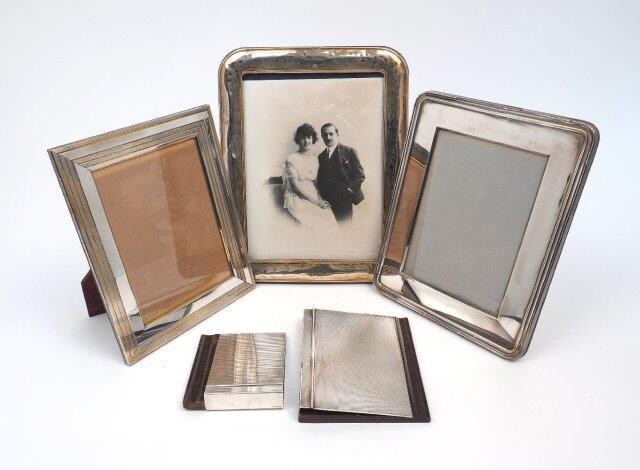 Two silver plated photo frames by Christofle, both with easel backs, 19 x 23.8cm and 20.2 x 25.2cm, together with a a larger Italian example, stamped 925, 23.6 x 29.6cm, and two notebook holders, the covers of both stamped sterling, 925, to wooden...