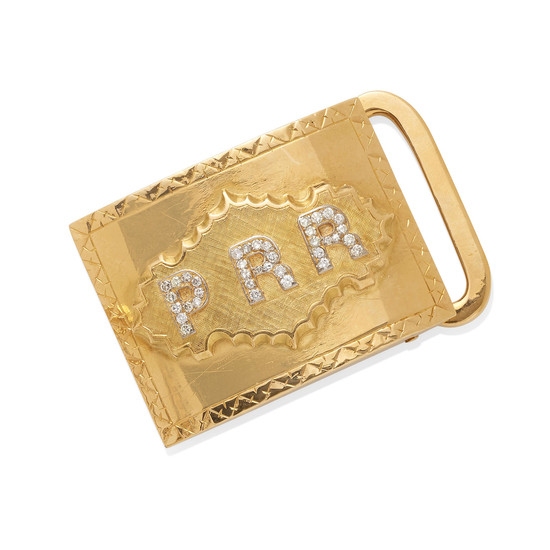 a gold and diamond monogram belt buckle