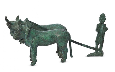 A bronze model of a farmer ploughing...