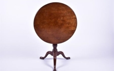 A George III walnut tripod tilt-top table the circular top raised above a birdcage and urn column supported on a tripod...