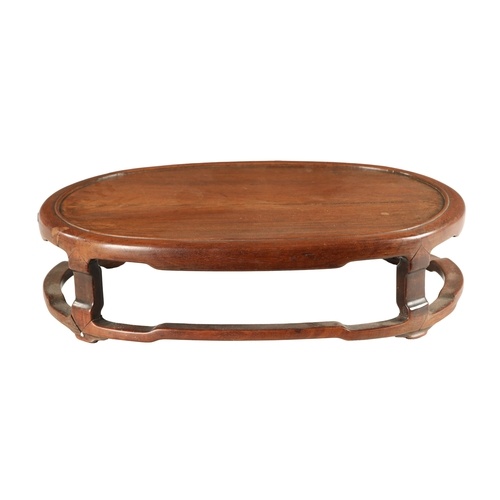 A 19TH CENTURY CHINESE HARDWOOD OVAL SHAPED JARDINIERE STAND...