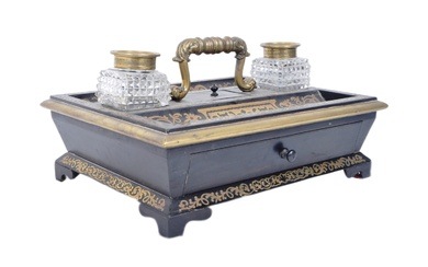 A 19th century Regency ebonised and Boulle work desk stand / tidy having a leaf work brass handle with small lidded compartment below flanked by cut glass inkwells with decorative brass covers. Brass inlaid decoration throughout with a single drawer...