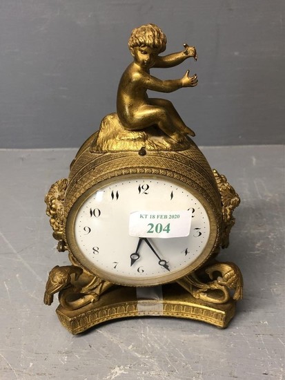 A C19th Ormolu clock with cherub finial and white face and b...
