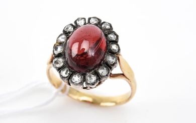 A CABOCHON GARNET AND DIAMOND RING IN GOLD