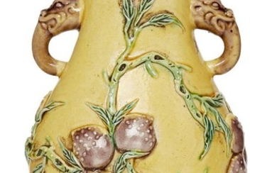 A Chinese aubergine and green-decorated yellow-ground vase, hu, 19th century, moulded to the body with a flying bat and a leafy branch with nine peaches, each side of the neck applied with two mythical beast handles, 13.5 cm high