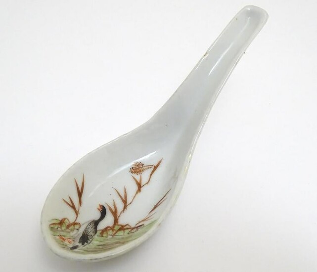 A Chinese soup spoon with hand painted decoration