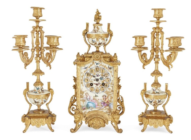 A French ormolu and porcelain mounted clock garniture, late 19th century, the central clock with porcelain and ormolu mounted urn finial above scrolling floral mounts, on caryatid scrolling feet, the porcelain dial painted with two lovers in a...