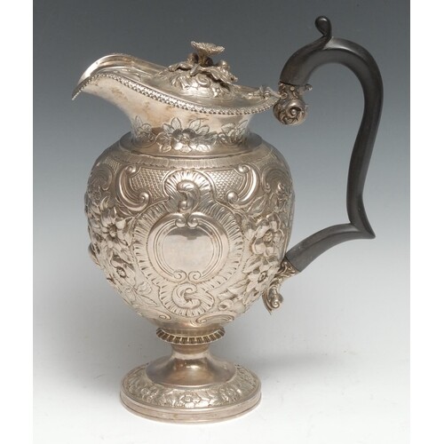 A George III Rococo silver pedestal claret jug, the ogee-sha...