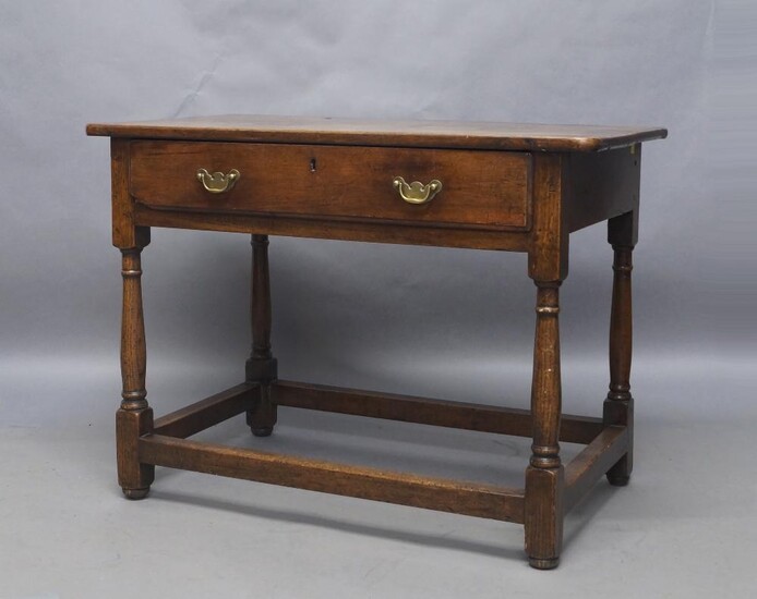 A George III oak side table, with single drawer, raised on fluted legs joined by stretchers and bun feet, 69cm high, 94cm wide, 53cm deep Provenance: Property of Future PLC, removed from the offices of Country Life magazine.