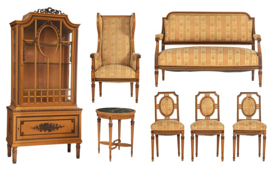 A Louis XVI style furniture set, containing a display cabinet, a round centre table, wall mirror, a wing armchair, and three chairs