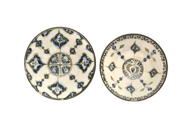 A NEAR PAIR OF COBALT BLUE AND BLACK-PAINTED POTTERY BOWLS WITH ARABESQUE MOTIFS Kashan, Iran, ca. 1200 - 1220