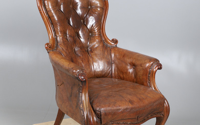 A VICTORIAN MAHOGANY LEATHER BUTTON BACK LIBRARY ARMCHAIR.