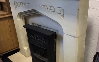 A faux limestone chimneypiece with rectangular mantlelshelf above a gothic...
