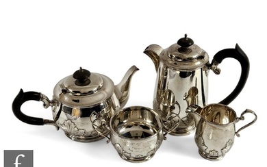A hallmarked silver four piece tea set decorated with part r...