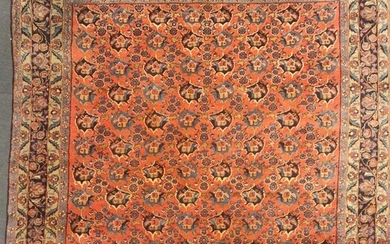 A large red ground rug with repeating floral motif and floral border, 375 x 302cm