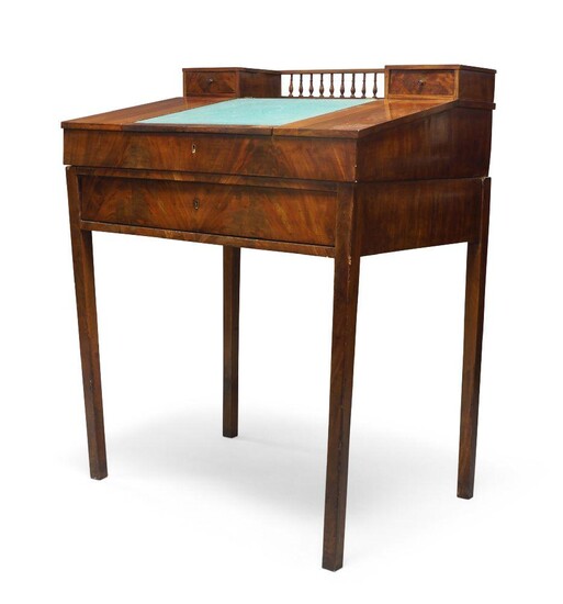 A mahogany slope front desk, probably continental, late 19th century, the back section with a spindle gallery set between two small drawers, the baize inset surface fitted with an internal door set between pigeon holes, having a large single drawer...
