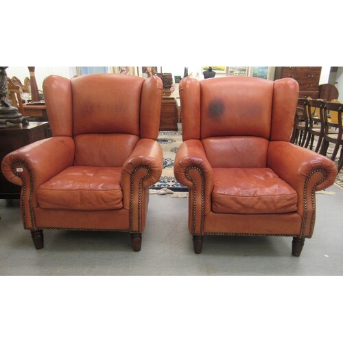 A pair of modern Georgian style wingback upholstered armchai...