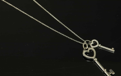 A platinum and 18ct white gold diamond set heart double key pendant