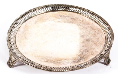 A sterling silver circular card tray with pierced border raised on three feet
