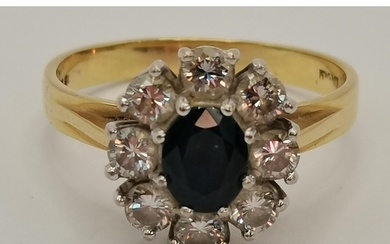 An 18 carat gold diamond and sapphire cluster ring, the oval...