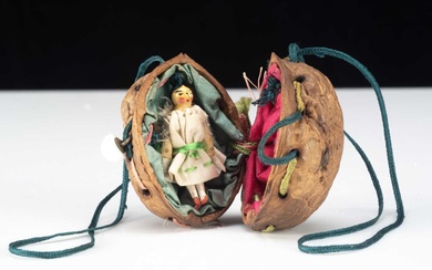 An 19th century miniature Grodnerthal doll in a walnut shell purse