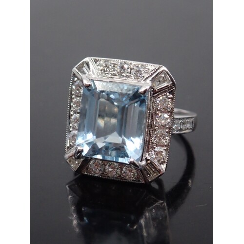 An aquamarine and diamond cluster ring set in 18ct gold fing...