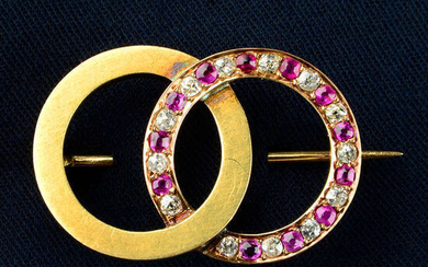 An early 20th century 18ct gold brooch, comprising alternating old-cut diamond, pink sapphire and polished interlocking circles.