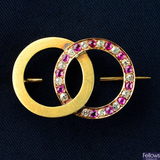 An early 20th century 18ct gold brooch, comprising alternating old-cut diamond, pink sapphire and polished interlocking circles.