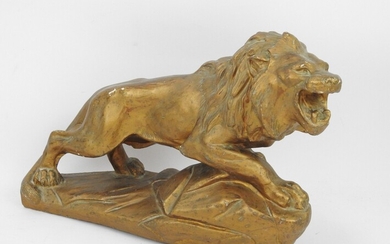 BIAGIONI : Lion en plâtre peint doré. Signé. Long : 50 cm. Quelques éclats de...