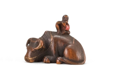 JAPANESE WOOD NETSUKE In the form of a herd boy seated on a reclining water buffalo. Some lacquer highlights. Length 1.5".
