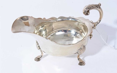 Late Victorian silver sauce boat of conventional form with scroll handle, raised on three hoof feet, (London 1898), all at 7.5oz, 17.5cm from handle to spout.