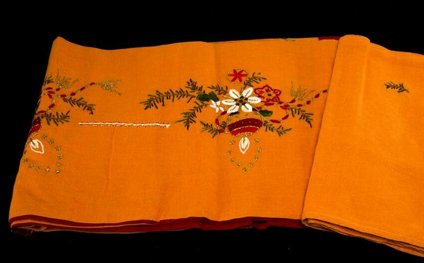 Linen tablecloth in orange with Christmas motifs.