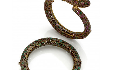 Lot of two gilt metal openwork cuff bracelets set with emeralds and rubies of various shapes and dimensions, diam. cm...