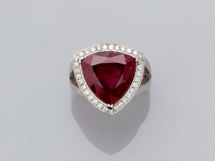 Ring in white gold, 750 MM, set with a beautiful triangular cut rubellite weighing 8.91 carats finely hemmed with brilliants, side 17 mm, size: 53, weight: 12.55gr. gross.