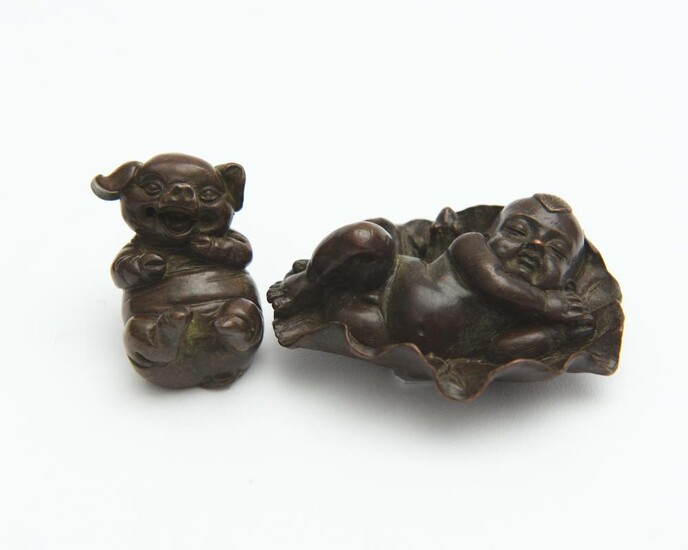 TWO SMALL BRONZE FIGURES: PIG AND BOY ON LOTUS, SIGNED