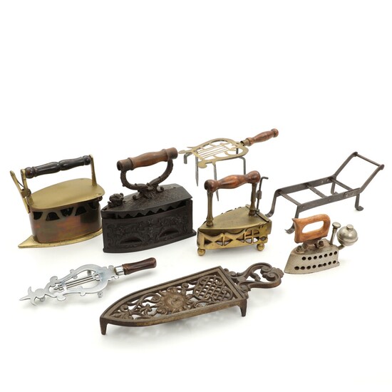 NOT SOLD. Various brass, wrought iron and steel flat irons and stands, wooden handles. Germany...