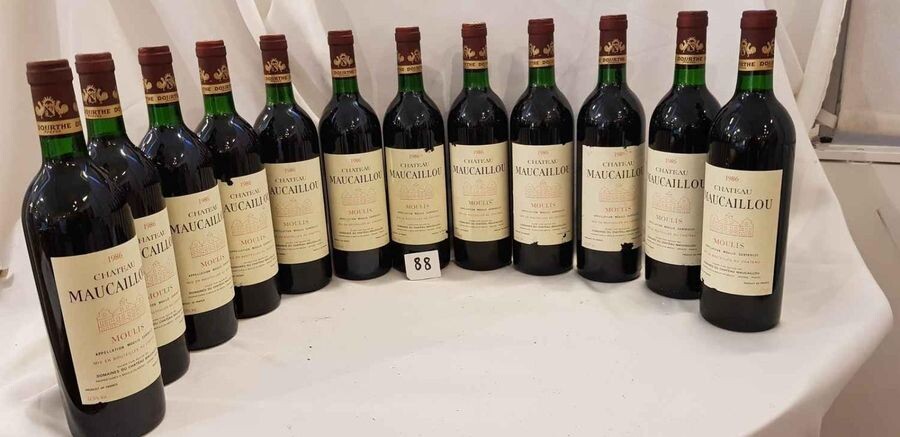 12 bottles château MAUCAILLOU 1986 MOULIS Beautiful presentation for 6 and 6 damaged labels. Low neck levels.