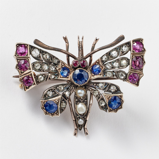 3075440. PENDANT/BROOCH, gold/silver, probably Russia, late 19th century, decorated with faceted sapphires and rubies, oriental pearls or rose-cut diamonds, in the shape of a butterfly.